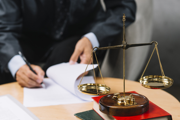 Consultor-juridico-assinando-o-contrato-com-escala-de-justica-em-primeiro-plano